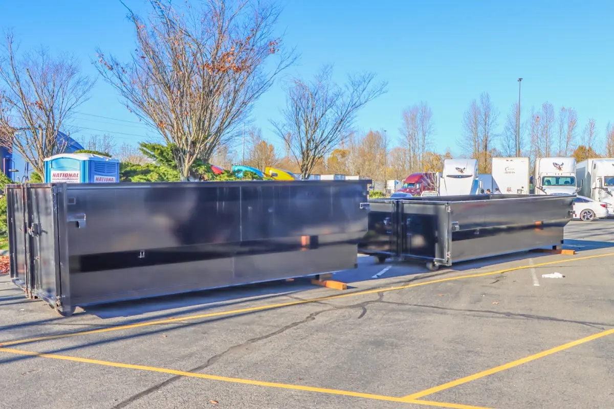 Professional dumpster rental service with roll-off container on residential driveway in West Goshen